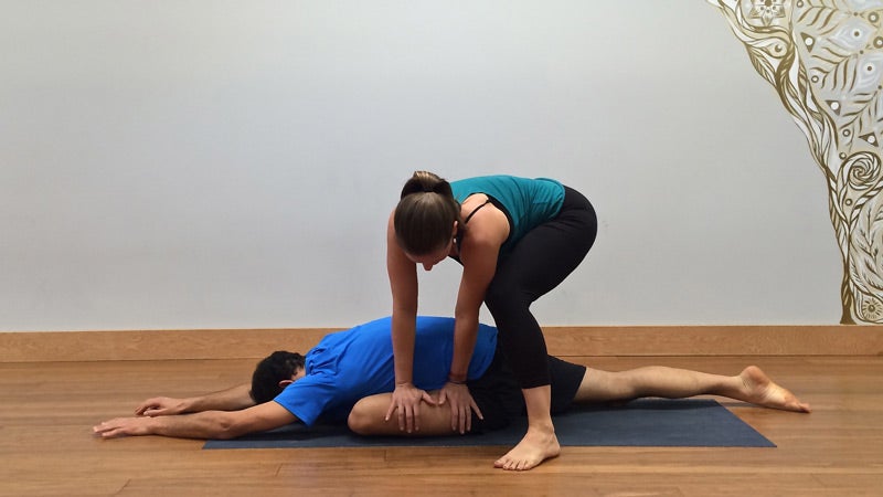Deven Sisler offering a hands-on assist for Pigeon Pose. Deven Sisler offering a hands-on assist for Pigeon Pose.
