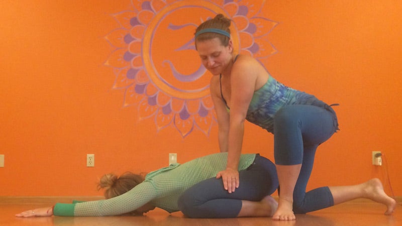 Deven Sisler offering a hands-on assist for Child's Pose. Deven Sisler offering a hands-on assist for Child's Pose.