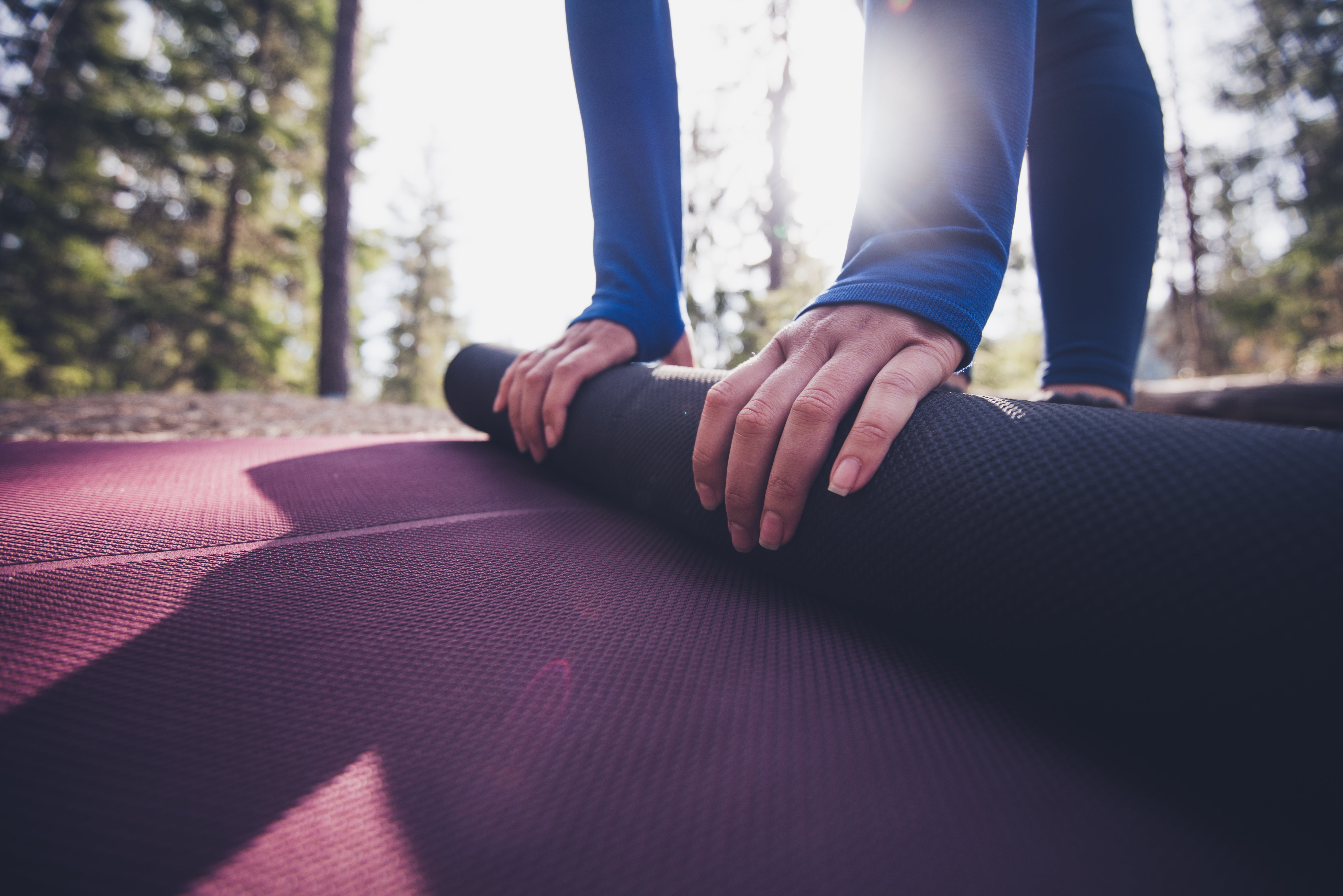 iStock-1148617437 A person rolling up a yoga mat