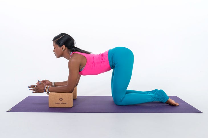 A person demonstrates how to practice Cow Pose with your forearms on blocks