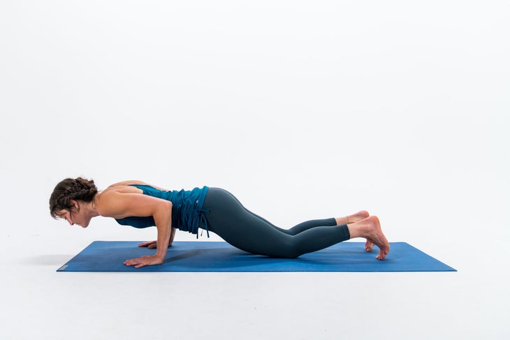 A person demonstrates a variation of Four-Limbed Staff Pose (Chaturanga Dandasana) with their knees on the floor