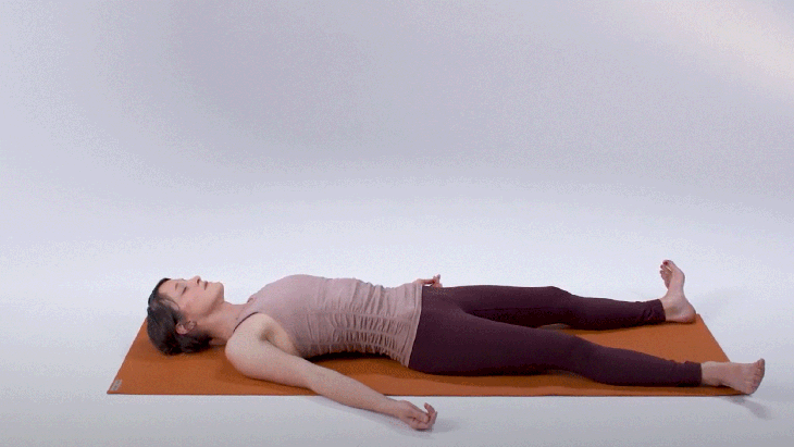 Woman demonstrates Corpse Pose