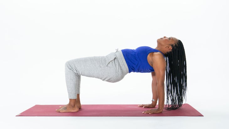 Woman does variation of Upward Plank Pose