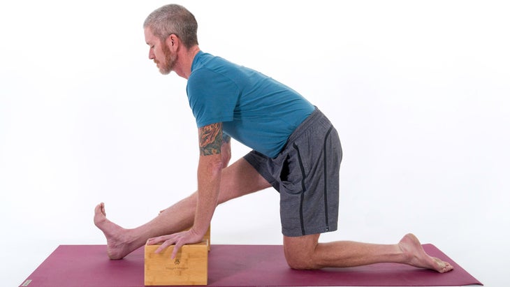 Man demonstrates a variation of Monkey Pose