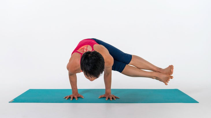 Woman demonstrates a modification for Side Crane (Crow) Pose