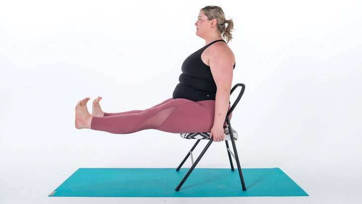 Woman demonstrates a variation of Staff Pose