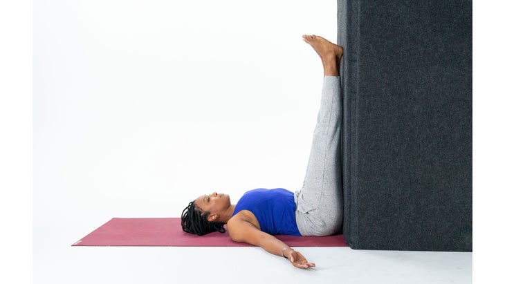 Woman with legs against wall vertical