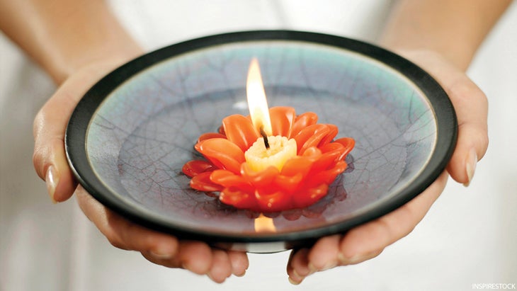 Woman holding a bowl of water with lit candle floating on it om_226_05 Woman holding a bowl of water with lit candle floating on it, inner light