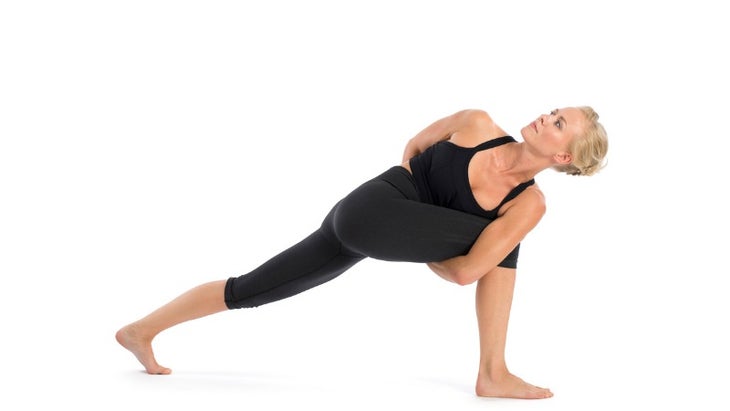 yoga-teacher-performing-parivrtta-parsvakonasana-asana-in-white-picture-id859643120 None