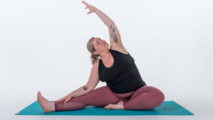 Woman doing Revolved Head-to-Knee pose variation