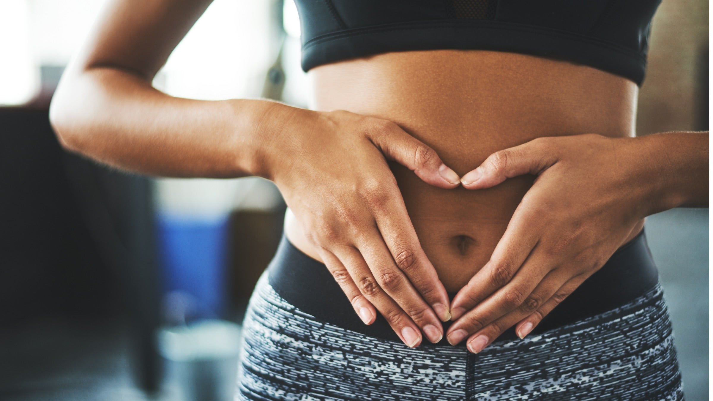 Hands making heart shape over navel