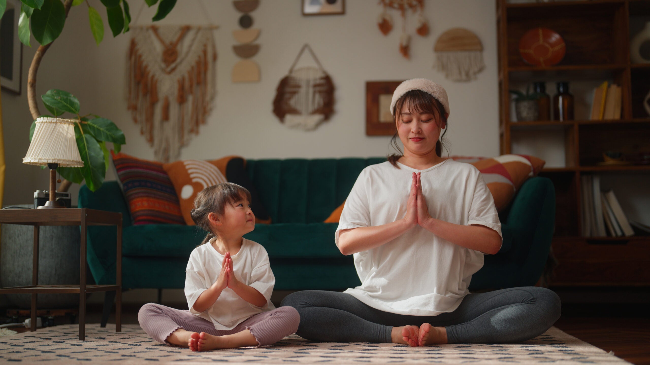 Mother and daughter practicing yoga at night.