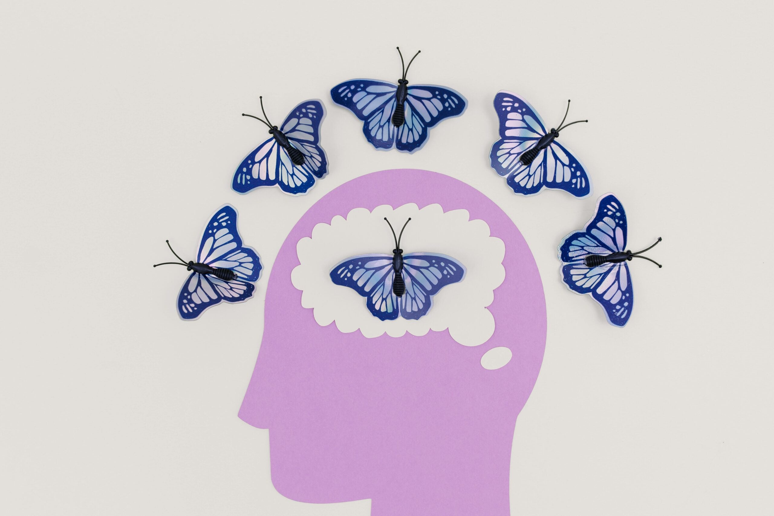 Illustration of a person's head surrounded by blue butterflies.