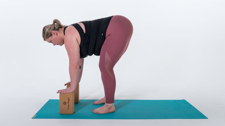 Woman performing variation of Standing Forward Bend