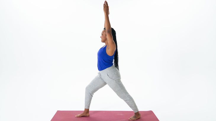 A woman demonstrates Warrior I Pose (Virabhadrasana I)