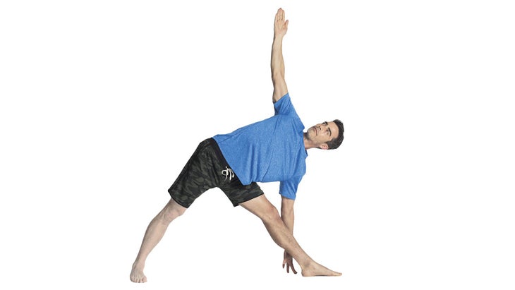 A man performs Utthita Trikonasana (Extended Triangle Pose) in yoga
