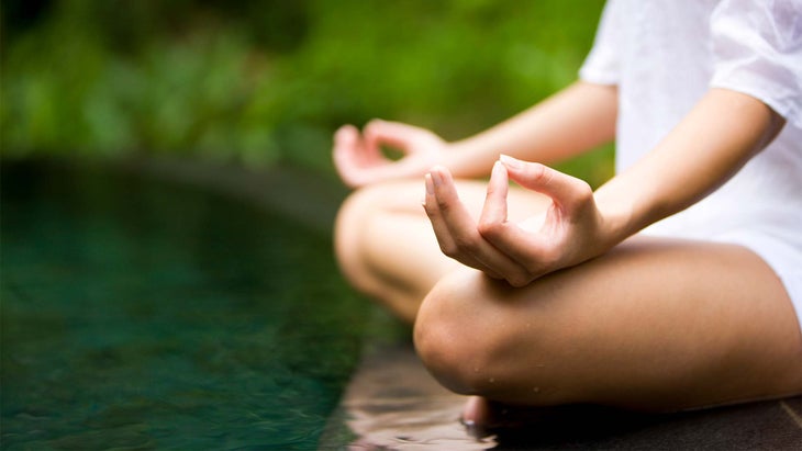 A person meditates with their hands in a gyana mudra