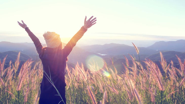 woman-nature-happy Woman looking out over landscape - arms above her head