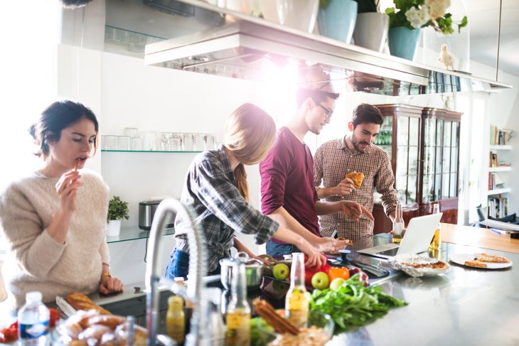 group-of-friends-eating-on-the-kitchen-and-preparing-food-531184054_6000x4004 None
