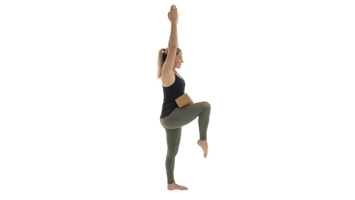 StandingKneeToChest woman practicing standing knee to chest variation