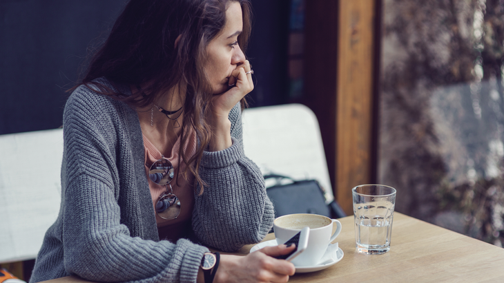 thinking-coffeeshop Woman sad, sitting in coffee shop