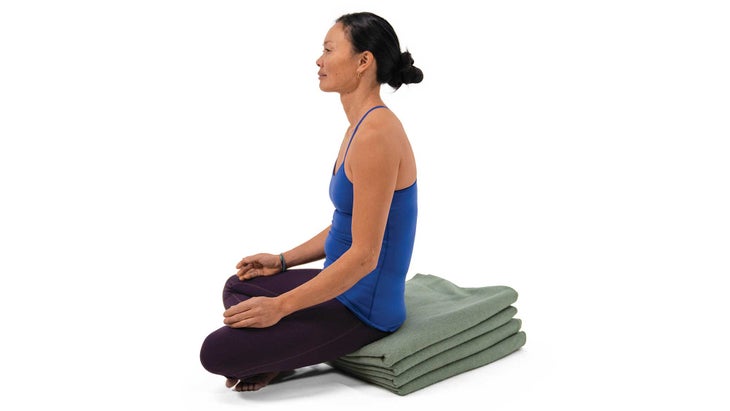 A woman sits in Easy Pose in yoga