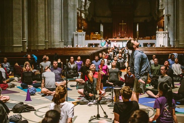 A diverse group of students practice yoga at Grace Cathedral