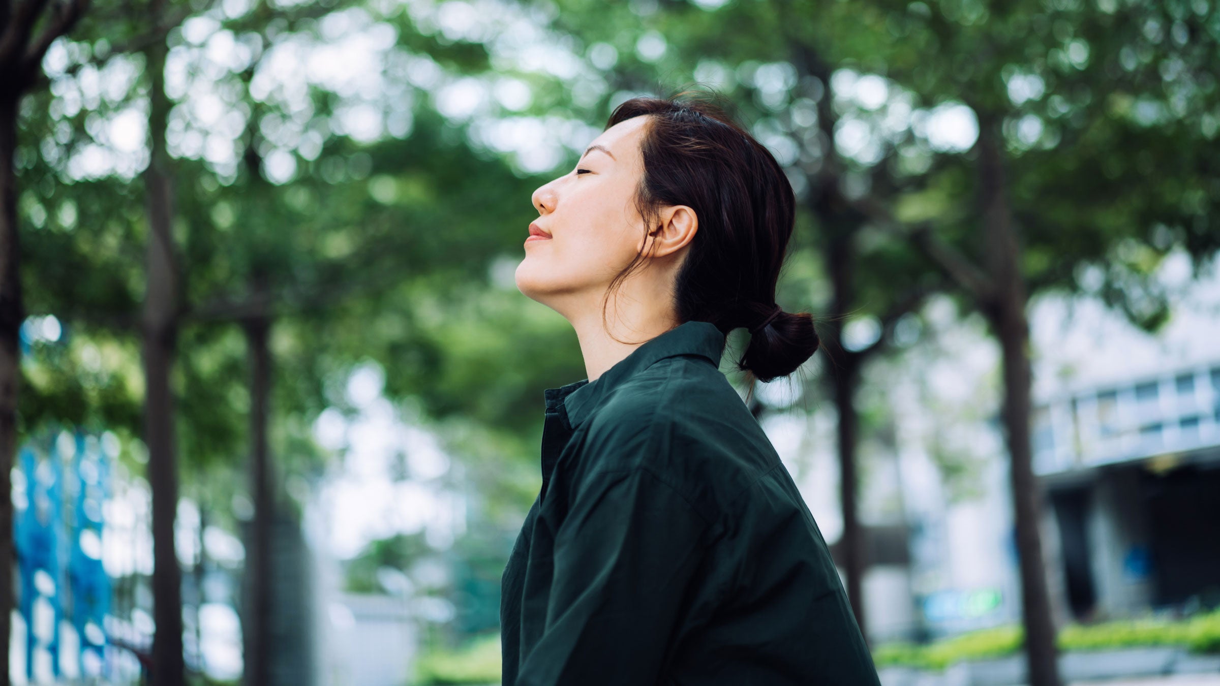 Woman stands with her eyes closed