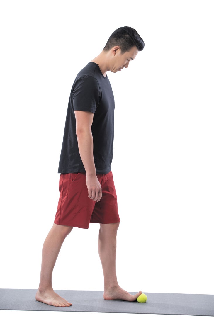 A man performs a standing big toe stretch