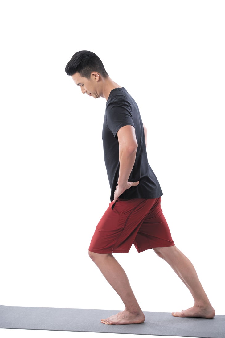 A man performs a standing ankle mobility exercise