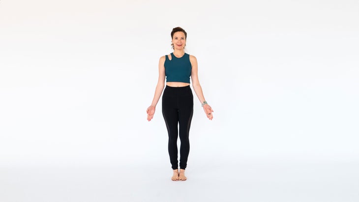 A woman stands in Tadasana (Mountain Pose)
