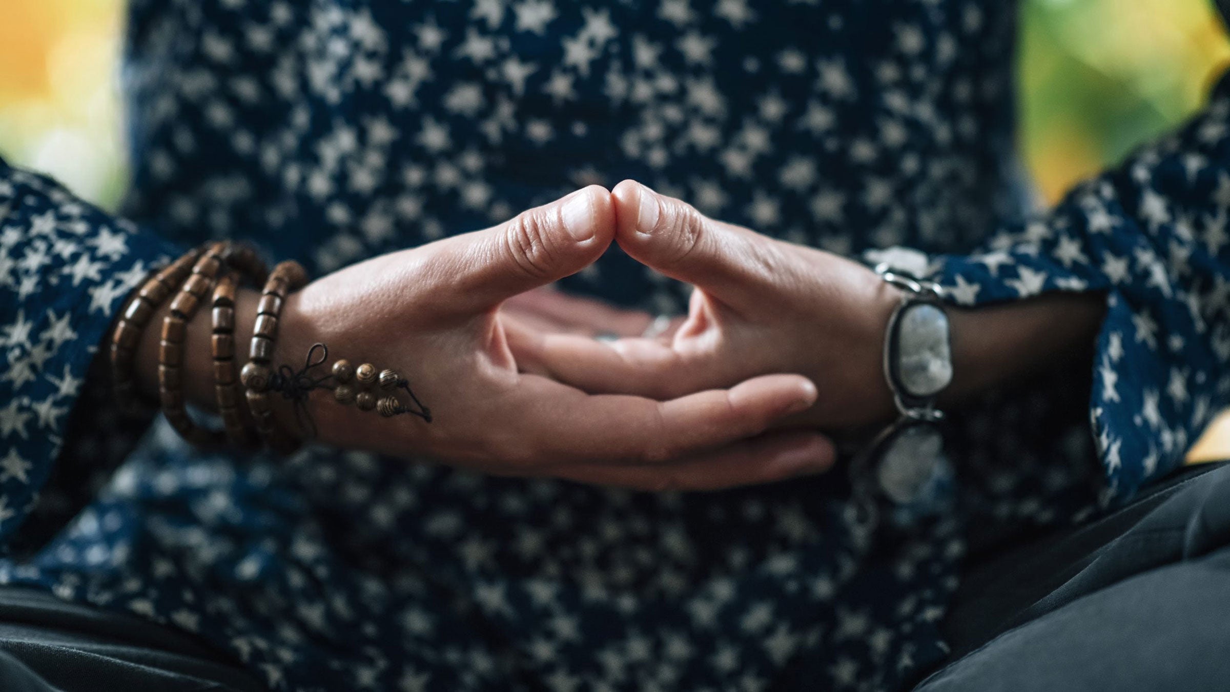 A person stands with their palms facing upward over their sacral chakra