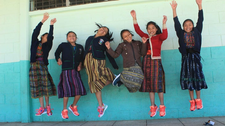 Children wearing new shoes donated by Soles4Souls jump in the air