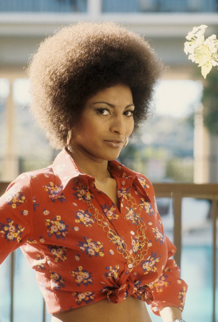 Actor Pam Grier circa 1972, in a red floral shirt and gold chain necklace
