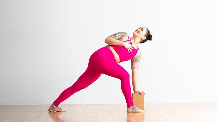 Woman in Revolved Side Angle variation with block