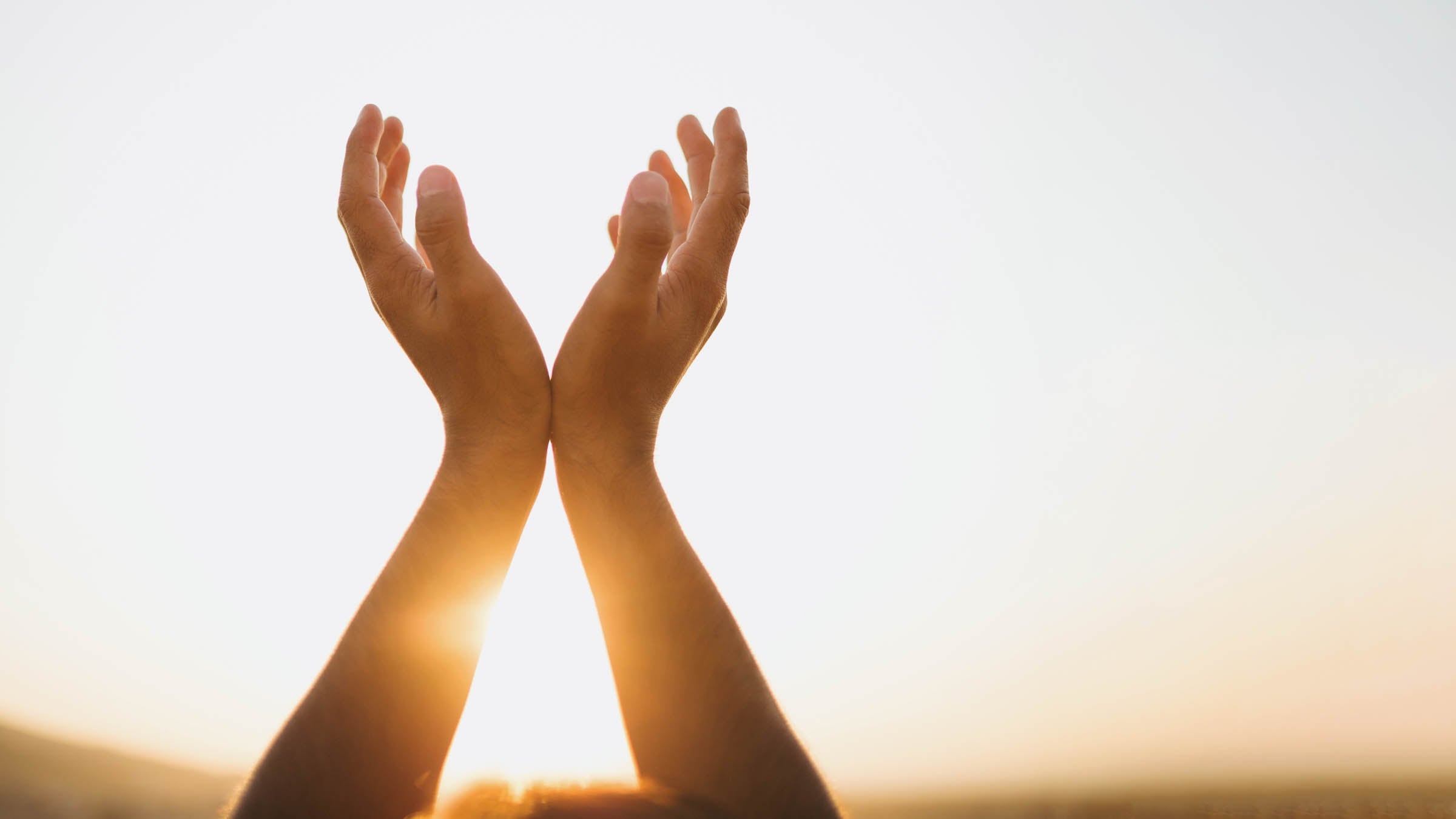 Hands reaching up to sun