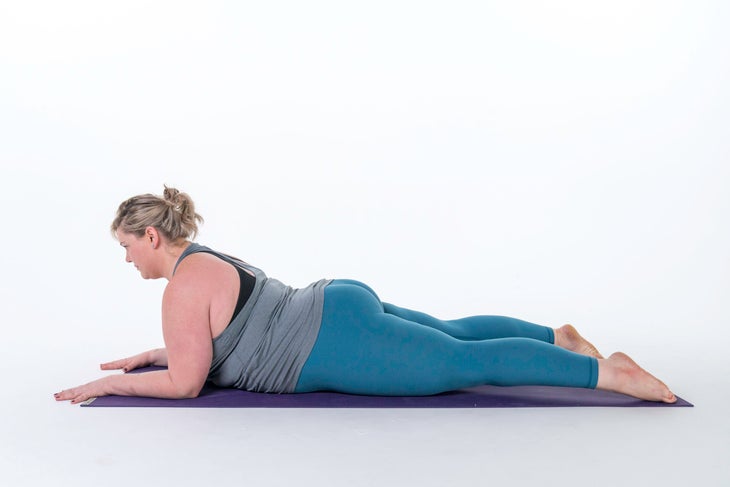 A woman demonstrates Sphinx Pose, a yoga pose for beginners