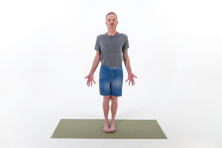 A man stands in Tadasana (Mountain Pose) in yoga