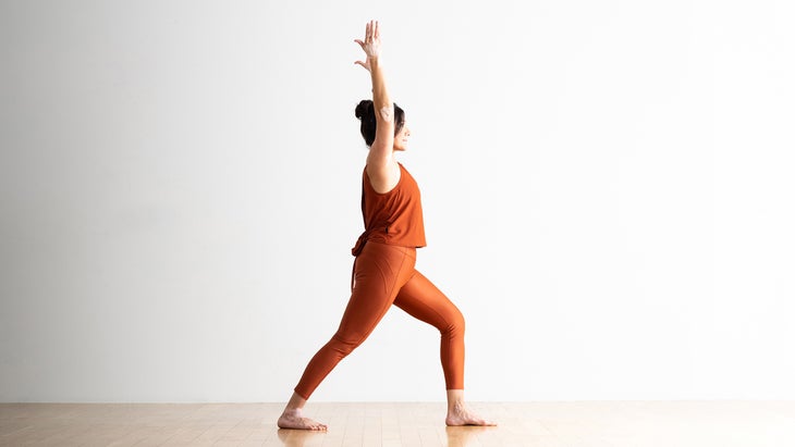 Person in Warrior I variation with a shorter stance