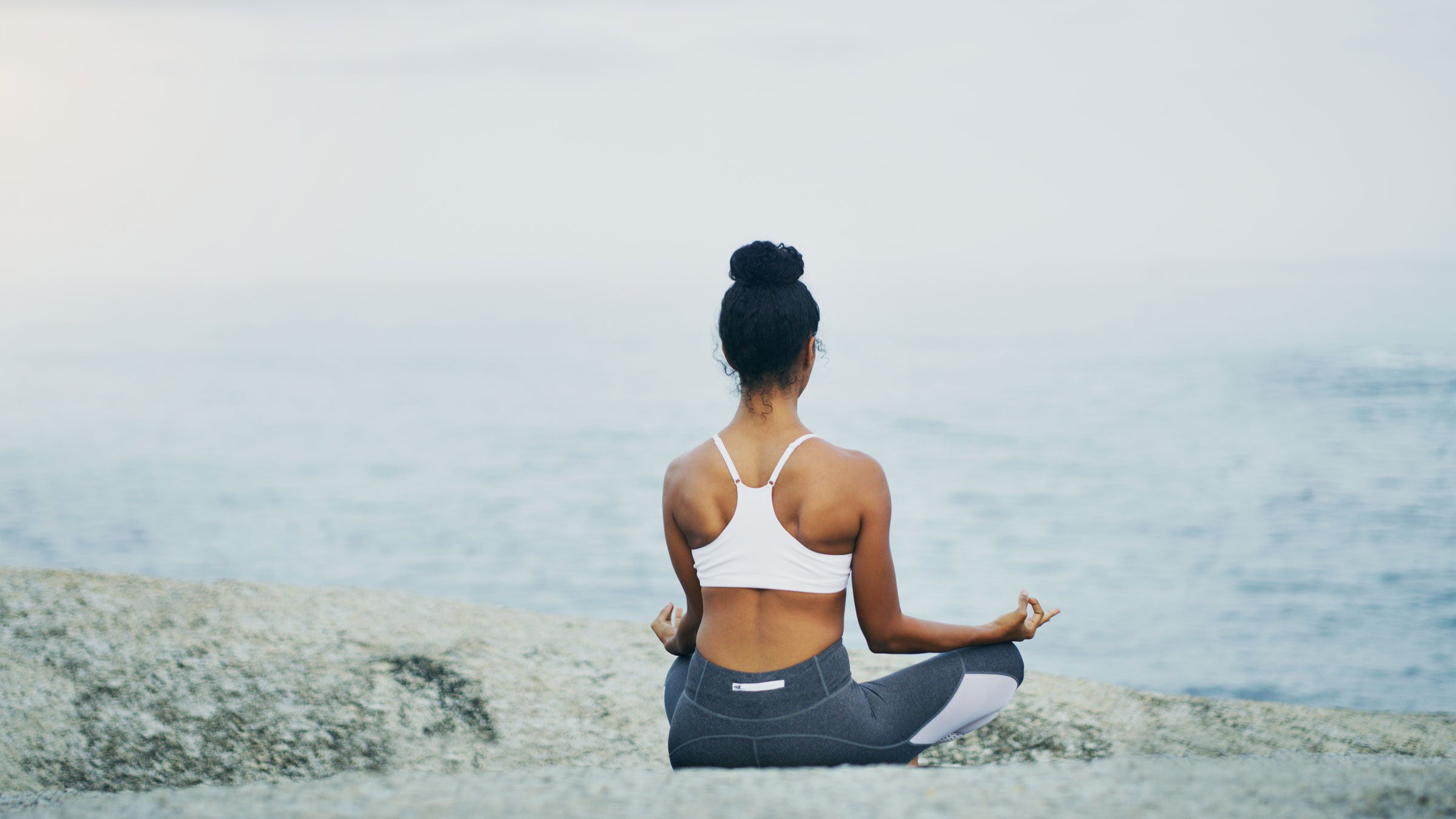 Woman meditates on the beach
