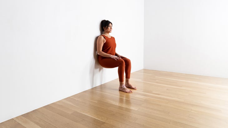 Woman in a Chair pose modification against a wall