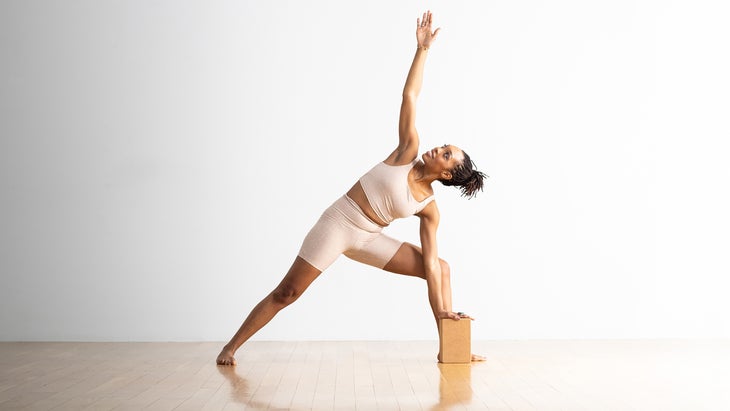 Woman performing Extended Side Angle modification with block