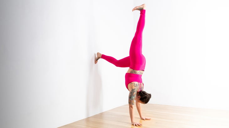 Woman in a Handstand modification against a wall