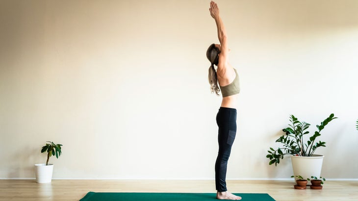 Woman stands in Upward Salute