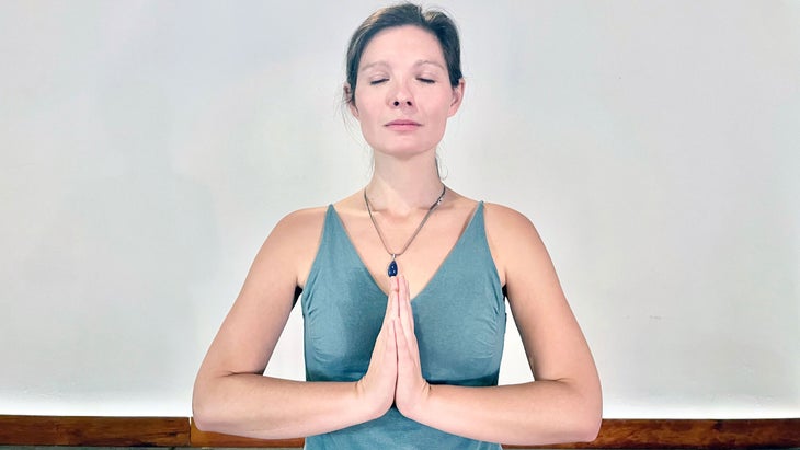 A person demonstrates Anjali Mudra in yoga