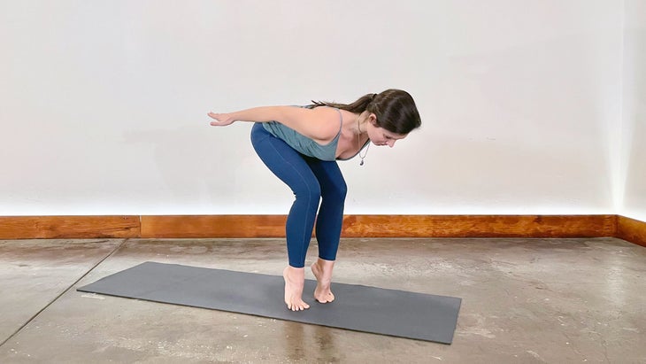 A person demonstrates Ardha Utkatasana (Chair Pose) on tiptoes in yoga