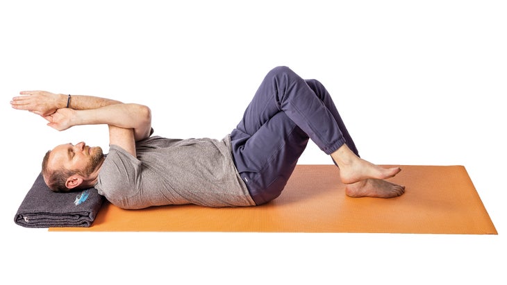 Jivana Heyman in a supine eagle pose variation