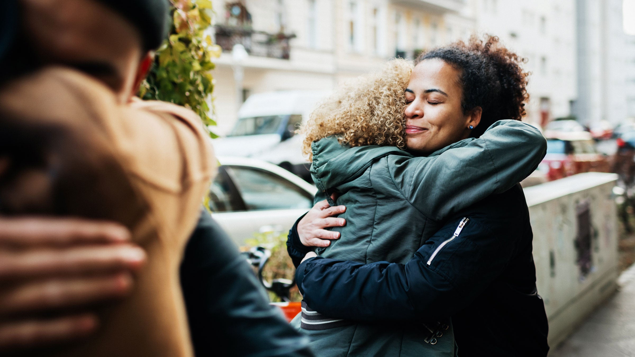 Two friends hug on a street
