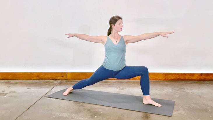 A person demonstrates Warrior II Pose in yoga