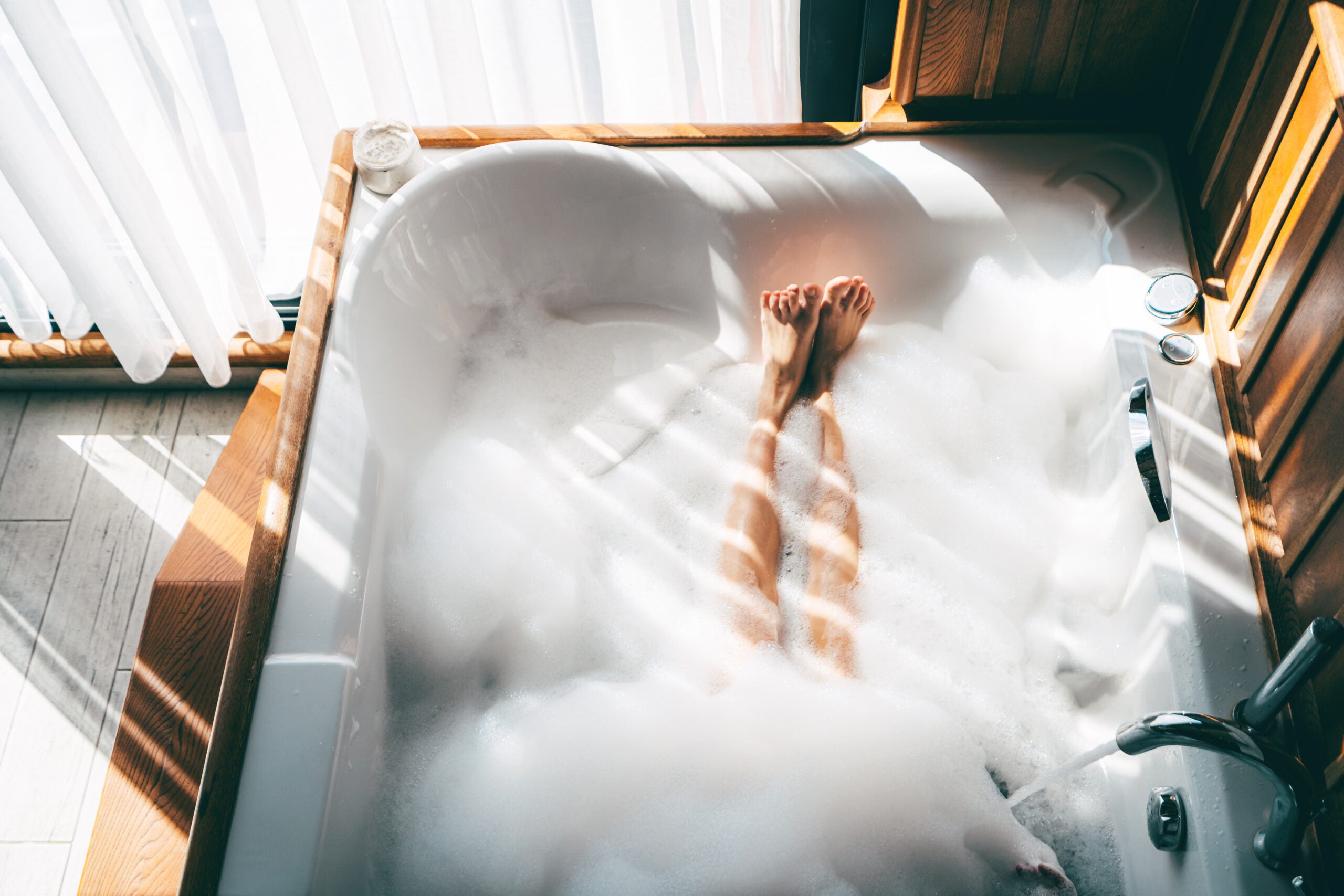 Image of woman's legs in a bubble bath.